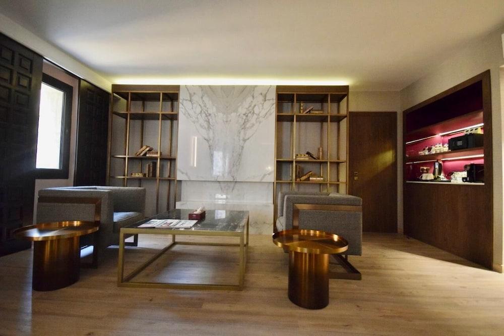 מכה Makarem Ajyad Makkah Hotel מראה חיצוני תמונה The photo shows a modern and stylish interior space, likely a living room or lounge area. On the left side, there are two comfortable gray armchairs positioned toward the center. A glass coffee table sits between them, featuring a few magazines or bo