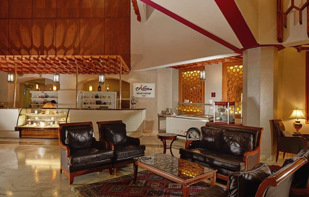 מכה Makarem Ajyad Makkah Hotel מראה פנימי תמונה The photo shows a stylish interior of a lobby or lounge area. It features a seating arrangement with dark leather armchairs and a wooden table in front of them. The decor includes an intricate ceiling design and decorative wall elements that add a wa