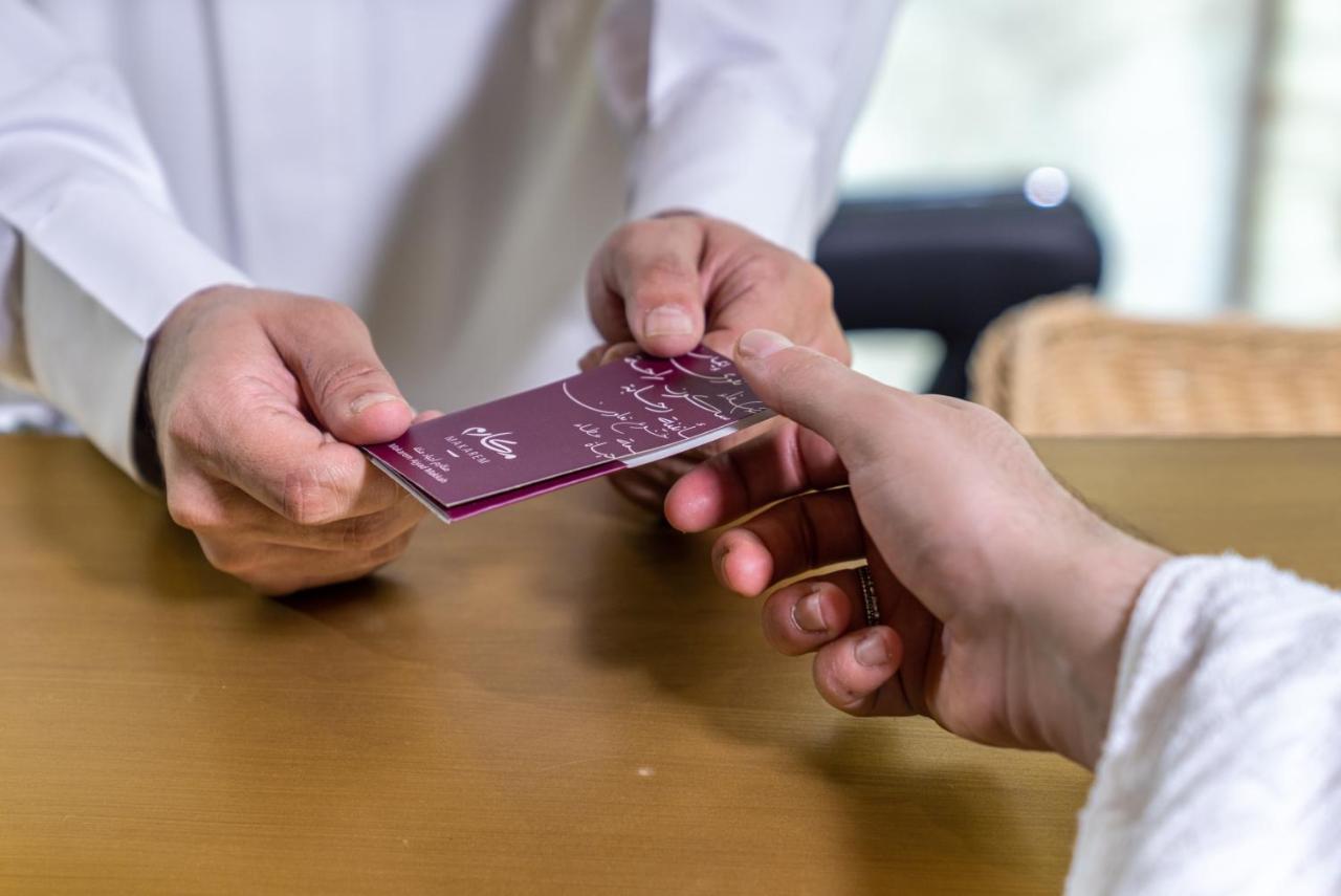 מכה Makarem Ajyad Makkah Hotel מראה חיצוני תמונה The photo shows two hands engaged in a transaction. One hand is extending a card towards another hand. The person handing over the card appears to be wearing a white garment, possibly a shirt or robe, while the person receiving the card has their han