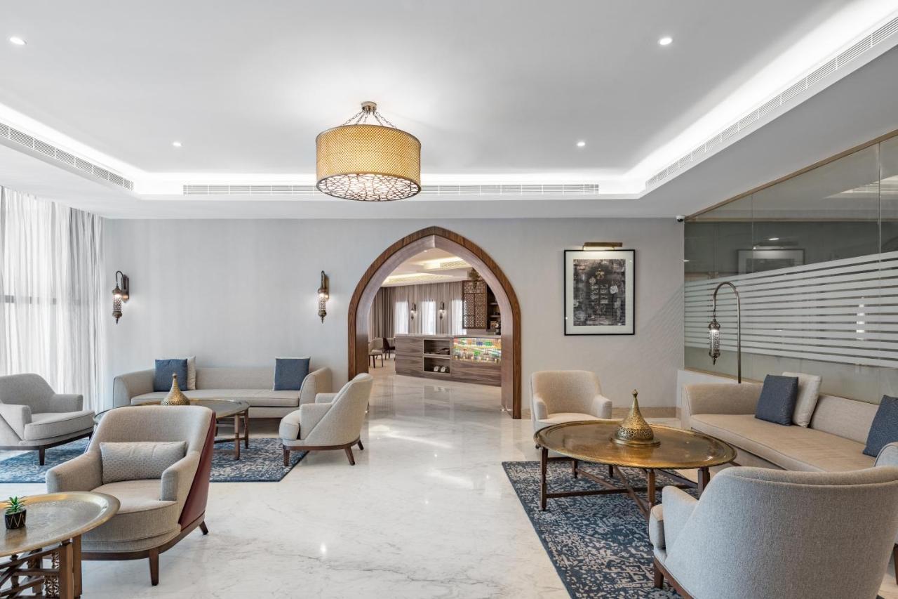 מכה Makarem Ajyad Makkah Hotel מראה חיצוני תמונה The photo shows a modern and elegantly designed lounge area. It features light-colored walls and marble flooring, complemented by stylish furniture including several armchairs and small tables. The lighting is soft, provided by a decorative chandelie