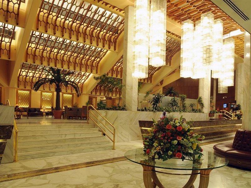 מכה Makarem Ajyad Makkah Hotel מראה חיצוני תמונה The photo shows a luxurious hotel lobby with elegant design features. It has high ceilings adorned with wooden beams and large, decorative light fixtures hanging from above. The lobby is brightly lit, creating a warm and inviting atmosphere. There ar