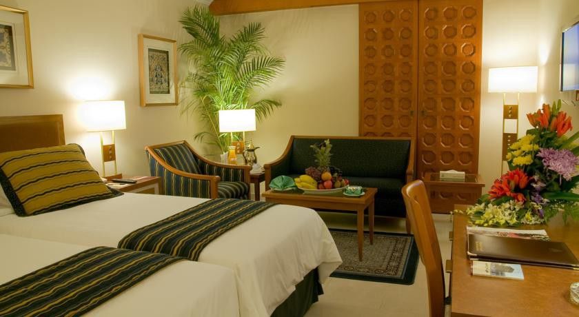 מכה Makarem Ajyad Makkah Hotel מראה חיצוני תמונה The photo shows a cozy hotel room that features two single beds with white linens and dark green and striped blankets. There is a decorative rug on the floor. Against one wall, there is a large wooden partition with a distinctive geometric pattern. T