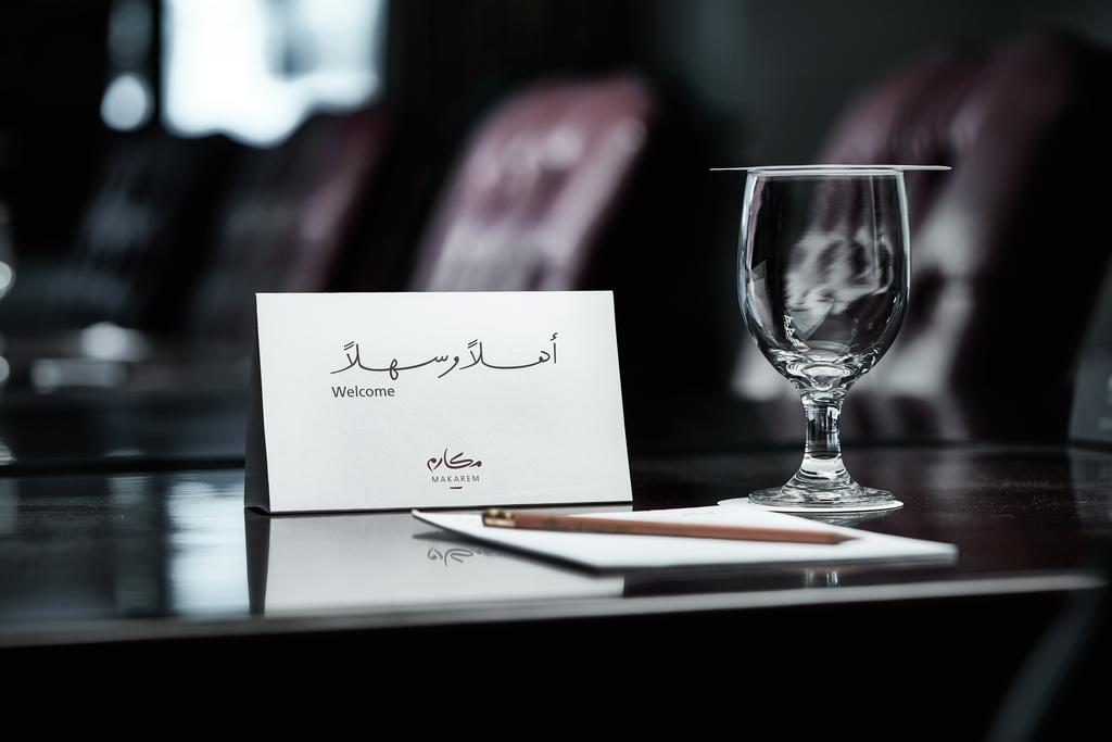 מכה Makarem Ajyad Makkah Hotel מראה חיצוני תמונה The photo depicts a well-arranged table setting. There is a card in both Arabic and English that says "Welcome," placed on the table. Next to the card, there is a clear glass and a pen resting on a piece of paper. The background features leather seat